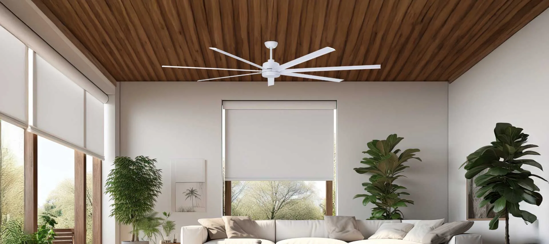 A white fan on a patio with a view of the outdoors, surrounded by green plants and trees, with a white sofa.