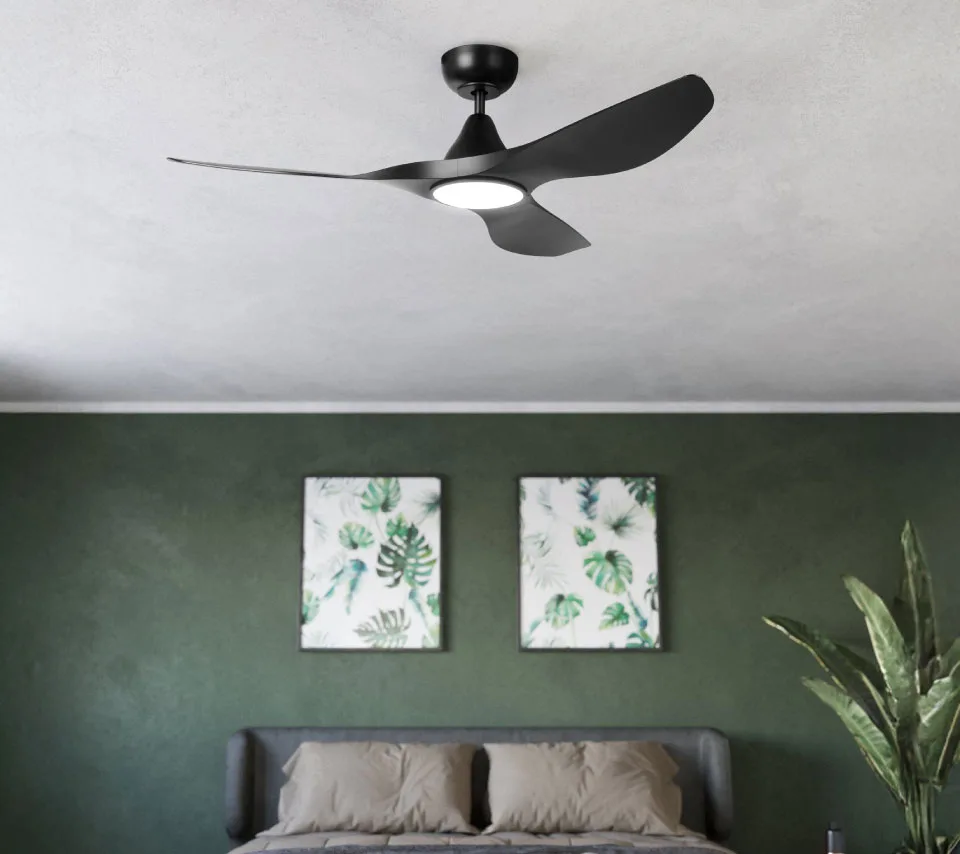Matte black ceiling fan with integrated light in a bedroom, featuring a tropical green and sage ambiance.