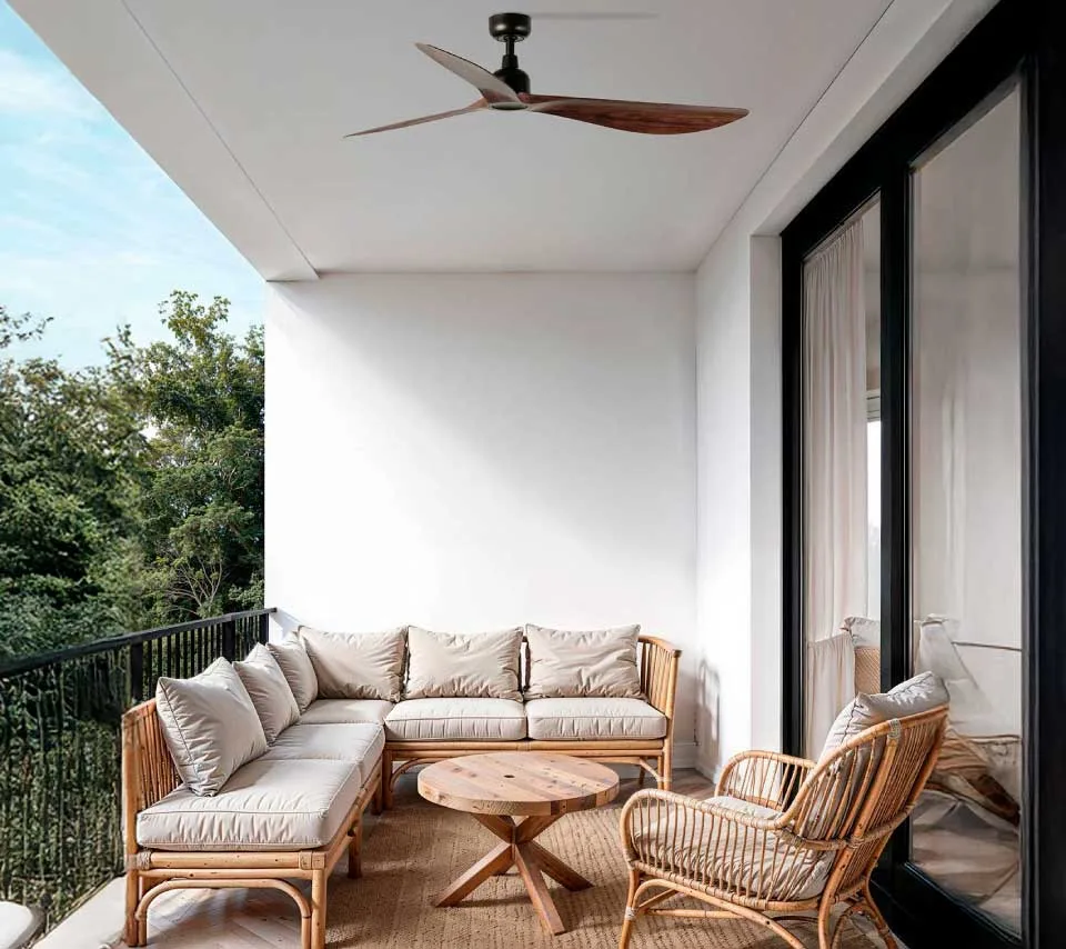 Natural wood fan on an outdoor terrace with a rattan sofa set, beige cushions, and a wooden coffee table in the center.