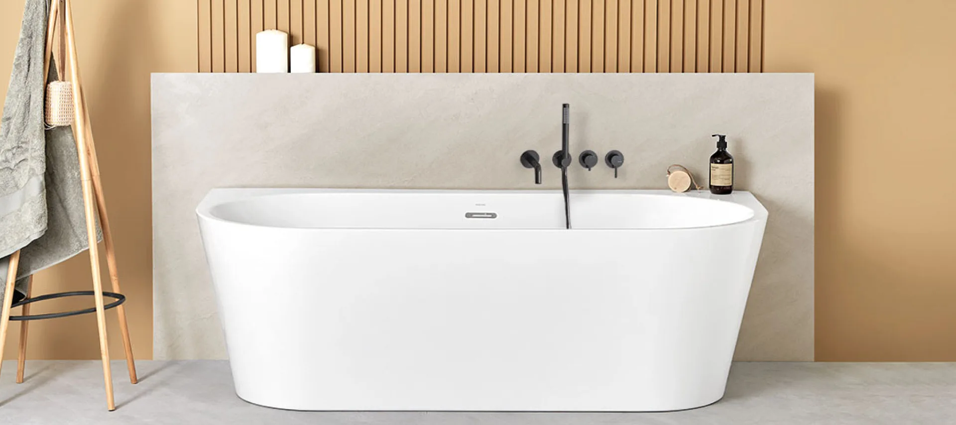 Modern freestanding white bathtub in a minimalist bathroom, featuring matte black wall-mounted faucet, vertical wooden slat wall panel, beige walls, and light concrete floor, creating a contemporary spa-inspired interior design.
