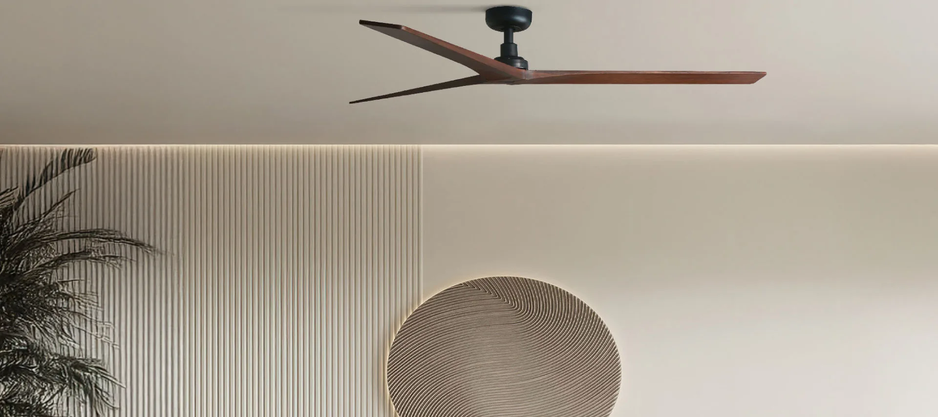 Modern wooden ceiling fan in a minimalist interior with textured wall and neutral decor
