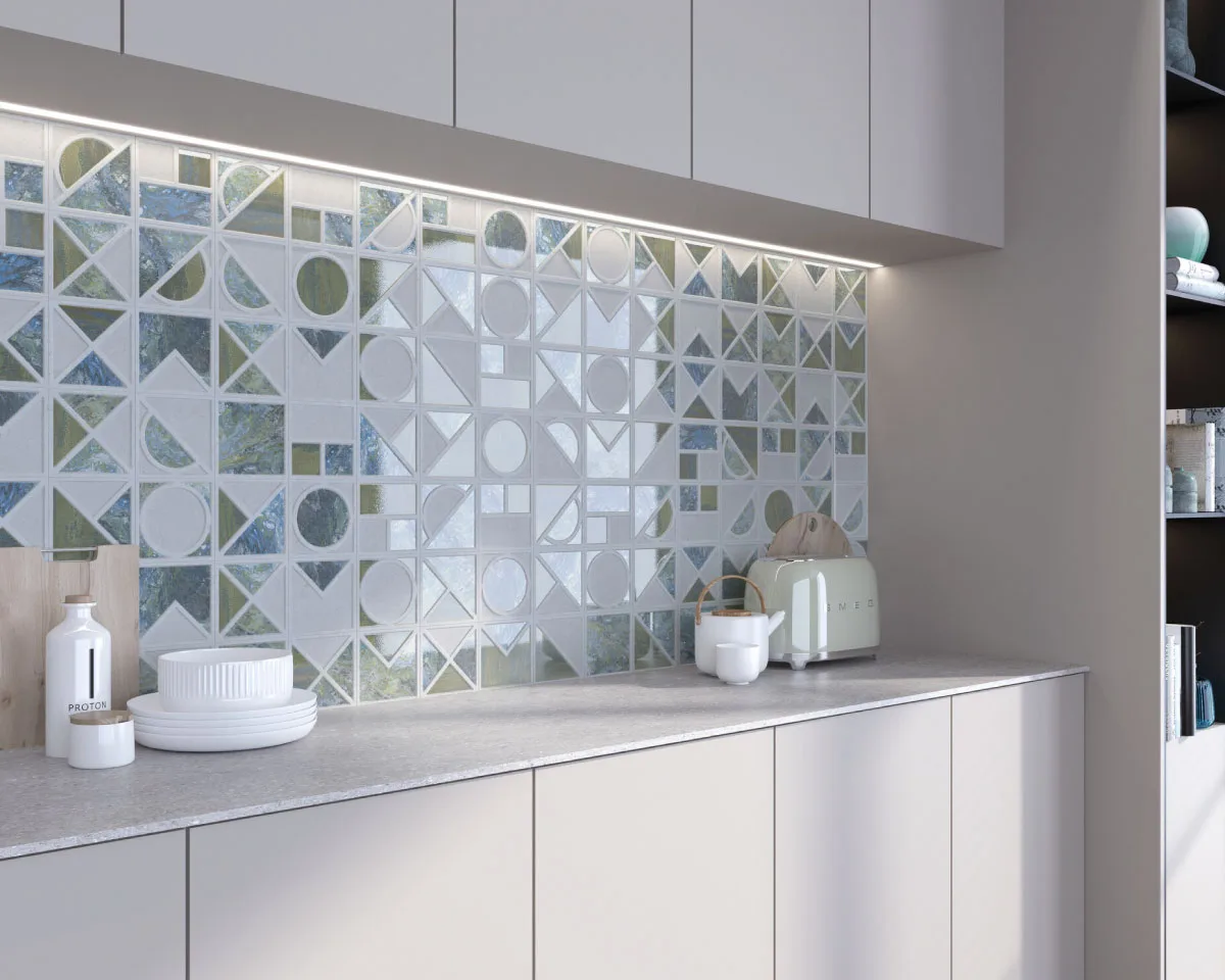 Contemporary kitchen featuring a decorative geometric glass tile backsplash, sleek white cabinets, stone countertop, under-cabinet LED lighting, and modern countertop accessories in a bright minimalist interior.