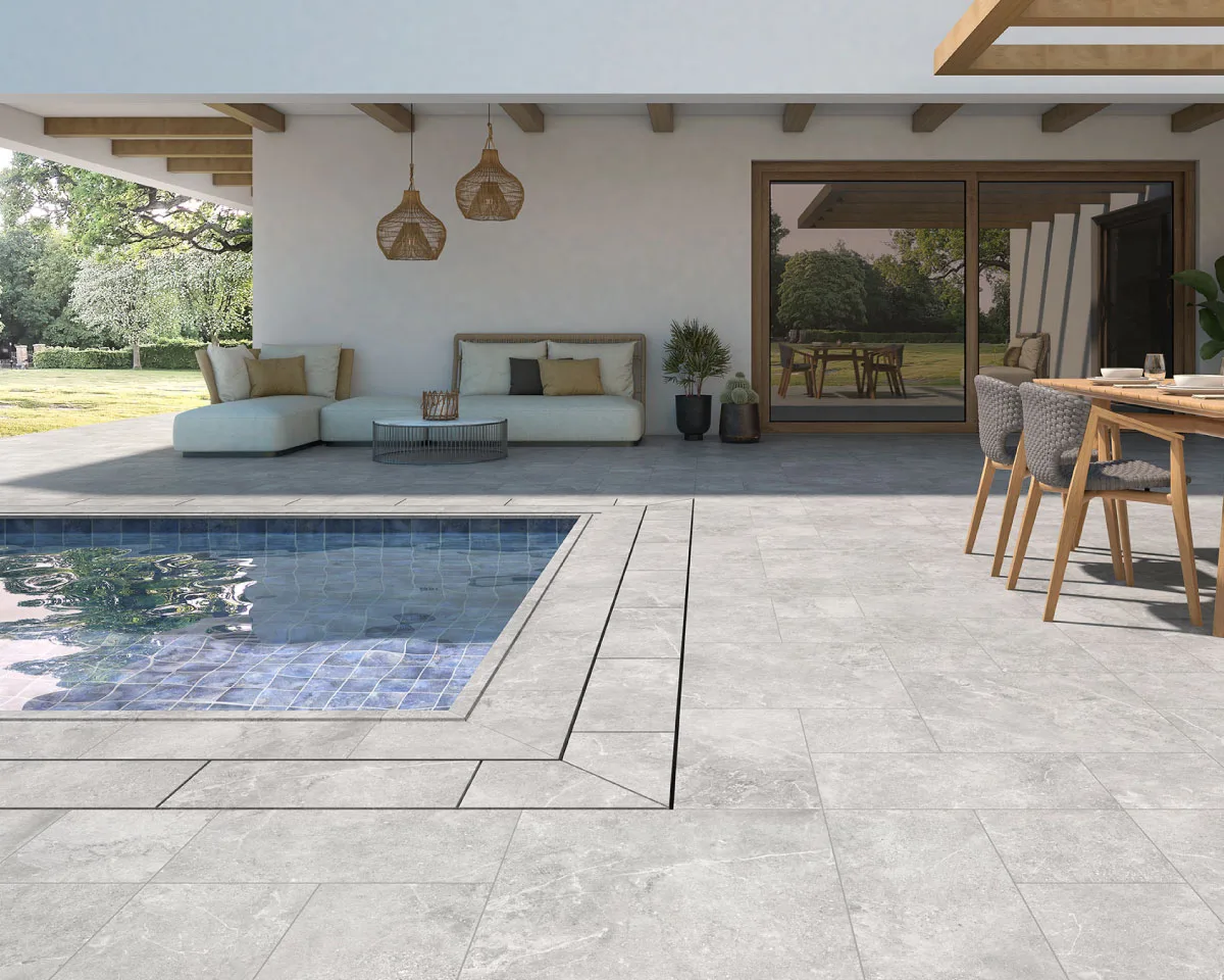 Contemporary outdoor terrace with grey stone-effect porcelain tiles around a swimming pool, modern outdoor furniture and covered patio.